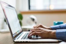 Close-up of a person typing on a laptop.